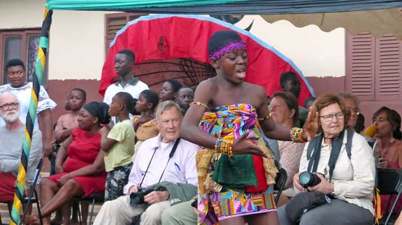 The young girl dancing and singing before the tourists.