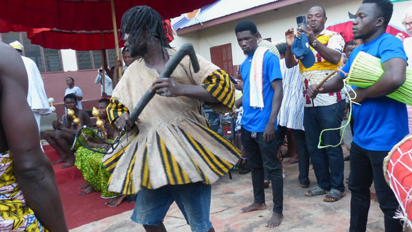 The priest spinning with a wooden tool in his hand. 